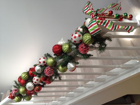 Use straight across the bookcase with bells falling on either side. Stairs Garland, Christmas Bannister, Christmas Staircases, Christmas Garland Staircase, Staircase Christmas, Christmas Banister, Christmas Stairs Decorations, Staircase Decor Ideas, Christmas Staircase Decor