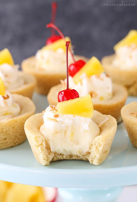 These Pina Colada Cookie Cups are a coconut cookie filled with pineapple cheesecake. They are topped with a bit of whipped cream, pineapple and a cherry! Church Desserts, Life Love And Sugar, Pineapple Cheesecake, Spring Snacks, Hawaiian Desserts, Coconut Cookie, Cookie Cups Recipe, Tropical Desserts, Pina Colada Recipe