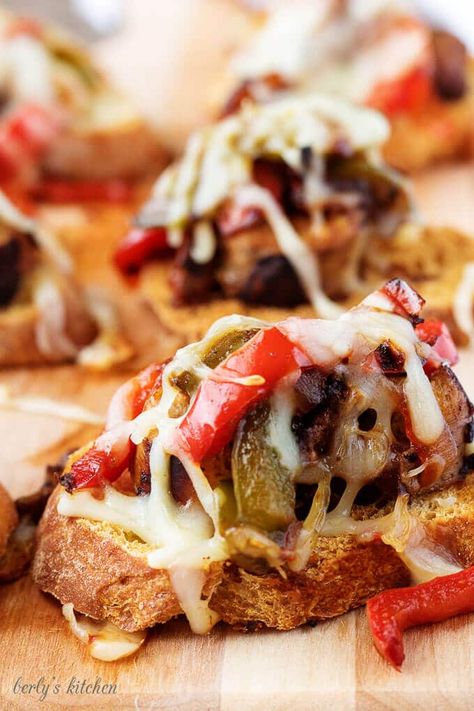 A final photo of the finished recipe for sausage and peppers crostini with melted cheese on top. Sausage Crostini, Recipe For Sausage, Pasta Primavera Recipe, Simple Appetizer, Crostini Appetizers, Cooking Whole Chicken, Sausage And Peppers, Appetizer Bites, Italian Dinner