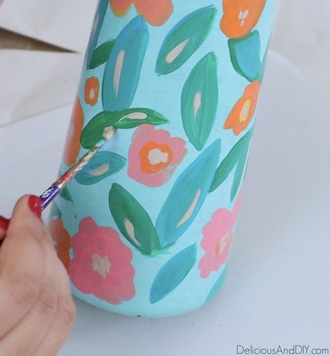 Learn how to transform a basic dollar store vase into a stunning spring-inspired with gorgeous painted flowers and leaves| Painted Dollar Store Vase using Glass Paints and transform it into a stunning decorative Vase. #dollarstorevase #dollarstorehacks #springinspired #floralvase #glasspaints Painting Vases Diy Ideas, Diy Painted Vases, Flower Vase Design, Long Vases, Light Blue Paints, Painted Glass Vases, Painted Hats, Wine Bottle Diy Crafts, Hand Painted Vases