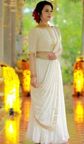 A traditional indian outfit with a white silk blouse featuring intricate designs, a pleated skirt, and a draped dupatta. accessorized with a necklace and bangles, it exudes classic elegance. Madhuram Veppu Dress, Onam Outfits Ideas, Kerala Dress, Long Skirt Top Designs, Onam Outfits, Long Skirt And Top, Indian Bridesmaid Dresses, Simple Saree Designs, New Saree Designs