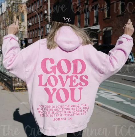 Introducing our God Loves You Pink Retro Font Bible Verse For Men And Women Christian Hoodie, a stylish and meaningful addition to your wardrobe. Crafted with comfort in mind, this hoodie is perfect for the modern Christian who seeks both fashion and faith. featuring a back-only design with a powerful message that serves as a reminder to anyone who comes across it, bringing not only comfort but also hope. This unisex heavy blend hooded sweatshirt is pure relaxation. It is made of a thick blend of cotton and polyester, it feels plush, soft, cozy, and warm, a perfect choice for any cold day or cool evening. In the front, the spacious kangaroo pocket adds daily practicality and is especially useful to warm those cold hands. Choose size & color from the drop-down menu. For more Christian Merch Kappa Hoodie, Faith Apparel, Jesus Clothes, Christian Shirts Designs, Christian Merch, Sorority Sweatshirts, Christian Hoodies, Tri Delta, Faith Clothing