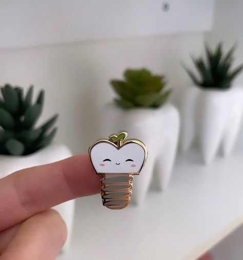 This dental im-plant enamel pin is .8 inch with the option to get an individual lapel pin or buy the set of 2! It makes the perfect gift for any pre-dental or dental student, or any dentists, dental assistants, dental hygienists, dental lab techs, or anybody who likes dental puns or plants! #Unlocking #FitLife #Dental #Care #Secrets #FitnessTips #NutritionTips #Tips #HealthyLiving #HealthTips #Smile #SelfCare #for #a #Radiant Dental Keychain, Dental Puns, Plant Enamel Pin, Dentist Art, Dental Hygiene Student, Dental Assistant Shirts, Dentist Logo, Dental Aesthetics, Dental Hygienist Gifts