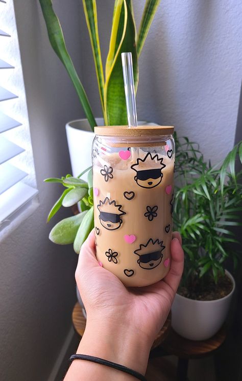 Anime merch is a must! Add this kawaii Gojo cup to your JJK collection! Our 16oz glass cups are great for your friends, family members, or just for yourself! The glass is durable and able to withstand both cold and hot beverages. The design is made with permanent vinyl and heat sealed to prolong the durability and life of the vinyl.  Order includes: 16oz glass cup, silicone sealed bamboo lid, and glass straw Anime Cup Designs, Kawaii Coffee Cup, Tumblr Designs Cup Sublimation, Drinking Glass Painting, Drawing On Glass Cups, Painted Glass Cups, Anime Tumbler Cup, Vinyl Cup Ideas, Glass Cup Painting Ideas