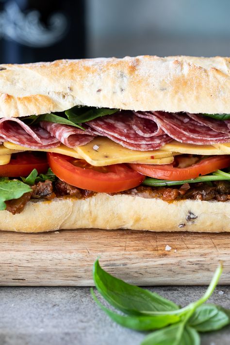 1 olive bread halved (alternatively use Ciabatta or French loaf) 1 cup Caponata Alternatively tapenade or pesto can be used 2 cups rocket/arugula 2 tomatoes sliced 50 g (+- 2oz) cheese (cheddar, provolone or mozzarella will all work well) 100 g (+- 4oz) salami fresh basil Special Cocktails, Husband Lunch, Salami Sandwich, Salami Recipes, Pizza Subs, French Loaf, Bahn Mi, Cheese Cheddar, Olive Bread