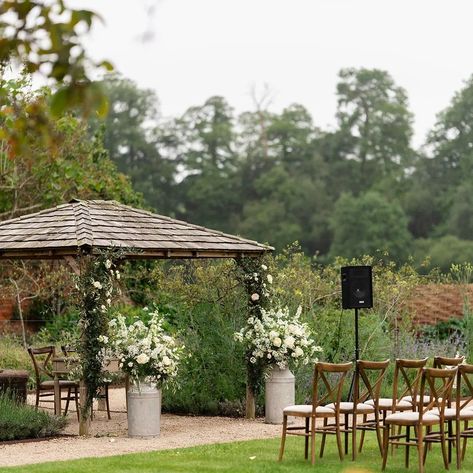 Ceremony set up for Holly & Elliott's wedding with frothy white florals in milk churns, jars of flowers hanging on shepherd hooks lining the aisle and subtle foliage and roses climbing up the pergola 🤍💚 Lovely photographs @scotthowardweddings #ceremony #weddingceremony #classicweddingflowers #whiteandgreen #weddingflorals #simplicity #elegantwedding Jars Of Flowers, Roses Climbing, Classic Wedding Flowers, Milk Churn, Flowers Hanging, White Florals, Wildflower Wedding, Elegant Wedding, Floral Wedding