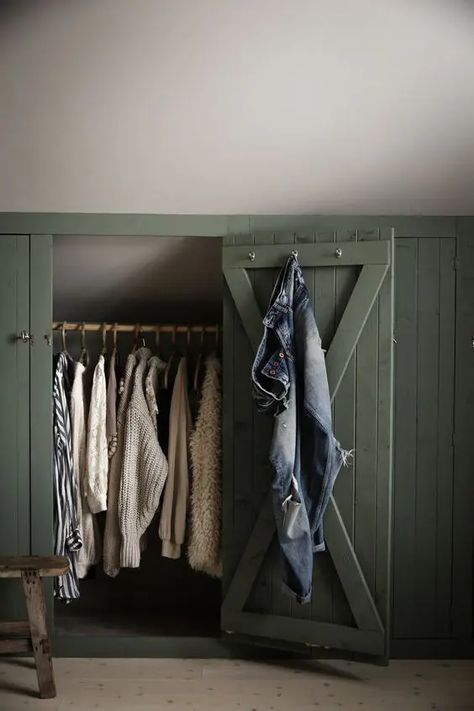 a sloped ceiling nook with green shiplap doors that hide railing for clothes is a smart solution for a farmhouse space Attic Bedroom Storage, Eaves Storage, Attic Closet, Attic Bedrooms, Attic Renovation, Attic Spaces, Attic Storage, Loft Room, Upstairs Bedroom