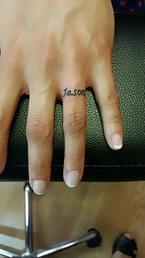 Wedding ring tattoo name tattoo wedding band Ring Finger Tattoo Couple Name, Ring Name Tattoo, Name Ring Tattoo, Name On Ring Finger Tattoo, Husbands Name Tattoo, Wedding Band Tattoo For Her, Husband Name Tattoos For Women, Wedding Rings Tattoo, Husband Name Tattoos