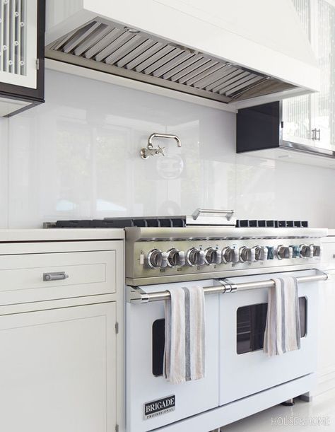 Custom-colored Starphire glass behind the range is easy to clean, as are the glossy cabinet fronts. | Photographer: Virginina Macdonald | Designer: Katherine Newman Hollywood Regency Kitchen, Bakers Oven, Custom Table Top, Cane Back Chairs, Cabinet Fronts, Kitchen Oven, Stylish Kitchen, Double Wall Oven, Kitchen Pantry