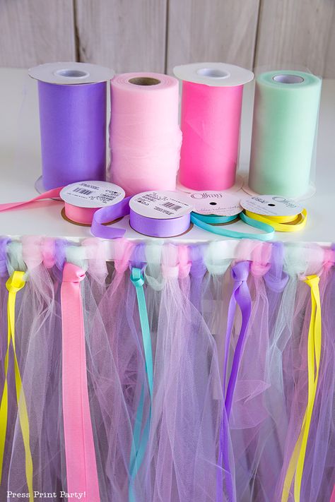 DIY Tulle Table Skirt: How to make a Rainbow, multicolored No Sew tulle table skirt tutorial. Perfect for your unicorn party, princess party, wedding, or baby shower. Learn how much tulle you need and use ribbons to add color and fun. Pink, purple, mint, yellow. By Press Print Party! #unicornparty #tulleskirt #diy Tulle Table Skirt, Diy Tulle, Tulle Table, Unicorn Birthday Party Decorations, Table Skirts, Unicorn Themed Birthday Party, Unicorn Party Decorations, Birthday Party Crafts, Unicorn Baby Shower