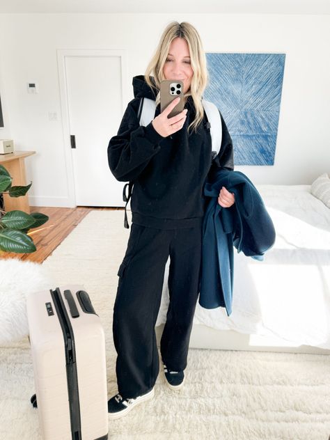 When pulling together a cool, cohesive airport outfits with sweatpants, start with a matching set in black or navy. They often look more expensive than they are, and black sweatpants can also – at a distance – vibe as real pants. I've been living in this set from Gap. Just add a wool wrap coat & some platform Adidas Gazelles and the whole look reads chic (but still comfy!) #AirportOutfit #AirportOutfitWinter #WinterAirportOutfit #SweatSet #WhatToWearOnThePlane #WinterTravelOutfit Sweats Airport Outfit, Cropped Sweatpants Outfit, Winter Sweatpants Outfit, Airport Style Winter, Black Sweats Outfit, Outfit Ideas Sweatpants, Wide Leg Sweatpants Outfit, Outfits With Sweatpants, Platform Adidas