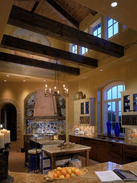 This modern Tuscan-style kitchen pays homage to the traditional details associated with the design through its use of color, architecture and accessories. Wood rafters help enclose the kitchen, while exposing the cathedral ceilings and intricate, artistic murals along the walls and ceilings. Simple wrought iron fixtures showcase Old World appeal with a contemporary edge. With massive wooden beams, terra-cotta tiles from Italy and hand-painted frescoes of Italian vineyards — this kitchen cook... Tuscan Home Decorating, Tuscan Architecture, Tuscan Design, Tuscan Kitchen, Tuscan House, Casas Coloniales, Tuscan Decorating, Ideas Room, Tuscan Style