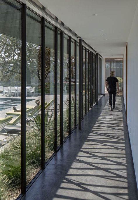 A long hallway with floor-to-ceiling windows connects the living areas of this modern house to the bedrooms. #ModernHallway #Windows Hallway With Windows, Exterior Hallway, New Modern House, L Shaped House, Corridor Design, Casa Loft, Long House, Sonoma Valley, Hallway Design