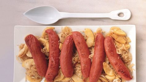 Bratwurst with Apples, Onion, and Sauerkraut Recipe | Epicurious Oktoberfest Bratwurst, Sauerkraut With Apples, Bratwurst Dinner, Sauerkraut Recipe, Sauerkraut Recipes, Ceramic Baking Dish, Homemade Applesauce, Tasty Recipe, Sliced Potatoes