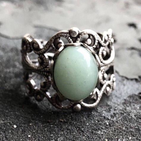 This stunning Victorian-style filigree ring features a 10x8mm oval sage green aventurine cabochon, showcasing its medium moss green hue and metallic iridescence from fuchsite inclusions. The modern vintage-inspired ring is fully adjustable. Choose between antiqued silver or antiqued brass. Aventurine is known for its beautiful shimmer and is believed to bring good fortune. Perfect for acubi, bookstore girl, or cottagecore-inspired outfits. Matching aventurine earrings that look good on a diverse