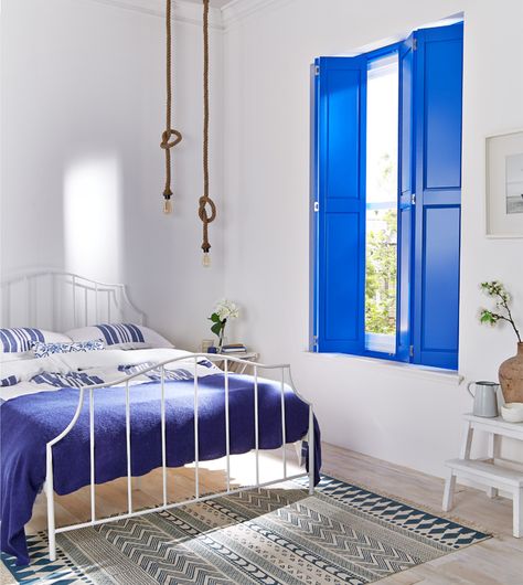 Greek dream interior - this is a space I designed for @hillarysblinds, I love these solid blue shutters, such a great way to add colour into a room in a easy way. The white walls, rope lights and white bedding add to that greek holiday feeling. Greek Bedroom, Santorini House, Blue Shutters, Coastal Living Rooms, Coastal Living Room, Dream Spaces, White Bedroom, Bedroom Themes, My New Room