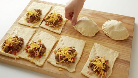 Beefy, Cheesy Taco Calzones Recipe - Tablespoon.com Taco Calzone Crescent Rolls, Taco Calzone Recipe, Loaded Cheesy Pocket Tacos, Taco Calzone, Mexican Fondue, Calzones Recipe, Pizza Dishes, Tacos For Dinner, Traditional Refried Beans