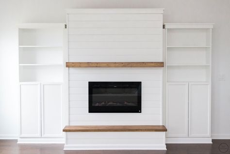 a modern farmhouse electric fireplace feature wall with built-in bookcases from IKEA, a floating mantle, and a wooden hearth Bookshelves Fireplace, Diy Electric Fireplace, Fireplace Electric, Fireplace Feature Wall, Basement Fireplace, Built In Electric Fireplace, Electric Fireplace Wall, Build A Fireplace, Shiplap Fireplace