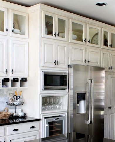 Small glass doors on upper cabinets. Microwave built in by fridge with wine glasses and wine refrigerator below Fridge Cabinet, Top Kitchen Cabinets, Upper Kitchen Cabinets, Above Kitchen Cabinets, Above Cabinets, Kitchen Cabinets Decor, New Kitchen Cabinets, Cottage Ideas, Mini Kitchen