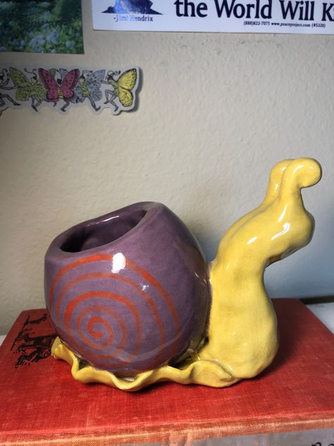 a ceramic snail with a pot made out of its shell. it is purple and yellow. Ceramic Room Ideas, Pitch Pots Ideas Clay, Unique Pinch Pot Ideas, Ceramic Pieces Ideas, Pinch Pots Aesthetic, Funky Ceramics Ideas, Ceramic Projects High School, Craft Clay Ideas, Clay Ideas Sculpture