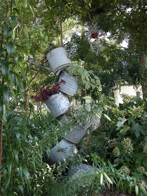 Metal tipsy pots.  This made a tall stacking of pots.  Notice I used a tall shepherd's hook and placed an old hanging lamp on the end.  The light is a styrofoam ball I covered with aluminum foil and glued flat red marbles to it. Diy Solar Fountain, Diy Water Feature, Flea Market Gardening, Diy Water Fountain, Diy Garden Fountains, Diy Fountain, Solar Fountain, Watering Cans, Air Terjun