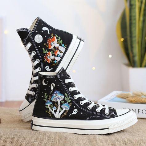 "Black Converse High Top shoes embroidered with mushroom garden and ghosts. With many years of shoe embroidery experience, this time I was really happy to receive a personalized canvas sneaker embroidery design for a very special customer. They sent me pictures of mushrooms in their favorite colors and they wanted me to combine it with ghosts. I found this request interesting and this was the gift they wanted to send to their loved ones. I also love this custom embroidery style. If you also need a pair of hand-embroidered Converse Shoes as a gift of the highest quality or a pair of hand-embroidered Vans Shoes, please message me. I will design and embroider a special pair of shoes. * The detail information of product: '' Custom Converse Chuck Taylor 1970s Embroidered Ghosts and Mushrooms Sn Beads On Shoelaces Converse, Embroidery Products Ideas, Etsy Converse, Sneaker Embroidery, Embroidered Mushrooms, Shoe Embroidery, Cute Converse Shoes, Embroidery Styles, Converse Design