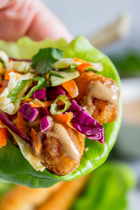 Thai Lettuce Wraps with Crispy Fish and Peanut Sauce from The Food Charlatan. These are a fabulous way to start off your January! Supple butter lettuce wrapped around crispy baked fish, topped with a gingery homemade Asian slaw. Drizzle with sweet and spicy Thai Peanut Sauce and you have an easy and healthy Asian-inspired weeknight dinner! #healthy #fish #crispy #cabbage #slaw #asian #Thai #peanutsauce #easy #sauce #lowcarb #lunch #simple #butterlettuce #greenonion #carrot #purplecabbage Lettuce Fish Tacos, Fish Taco Lettuce Wraps, Fish Lettuce Wraps, Fish Wraps, Grouper Recipes, Thai Lettuce Wraps, Salat Wraps, Lettuce Wraps Healthy, Thai Fish