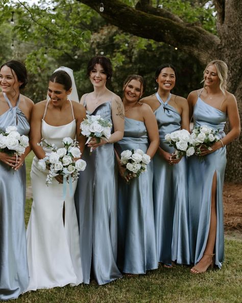 Dusty Blue Dreams  A palette of something blue comes to life in  shimmering satin bridesmaid dresses. #BIRDYGREY #birdyinthewild Capture the magic: @jaclyn_alt Photographer: @paytonuruetaphotography  Flowers and venue: @southernoaks378 Event planning: @truly_yours_events Hair: @k.b.glam Makeup: @atelierbridalmakeup   .#WeddingPlanning #BrideToBe #WeddingInspiration #EventPlanning #DreamWedding Dusty Blue Rustic Bridesmaid Dresses, Bridesmaid Different Shades Of Blue, Silvery Blue Bridesmaid Dresses, Satin Dusty Blue Bridesmaid Dress, Dusty Bridesmaid Dresses, Something Blue Bridesmaids, Dusty Blue Bridesmaid Dresses Mismatched, Dusky Blue Bridesmaid Dresses, Bridesmaid Blue Dresses