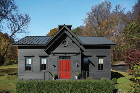 We love the look of a front door painted in a traditional red color. Paired with a dark gray exterior, this home stands out amongst the greenery. For more paint colors that marry traditional and modern design, visit our website to see the entire Benjamin Moore Williamsburg® Paint Color Collection.  House: Ambler Slate CW-685, Aura® Exterior, Low Lustre // Doors: King's Red CW-335, Aura® Grand Entrance®, Satin. Red Front Door, Gray House, Backyard Renovations, Painted Front Doors, Grey Houses, Grey Exterior, Exterior Paint Colors For House, Front Door Colors, Black House Exterior