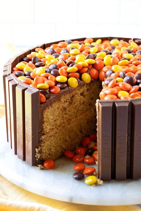 This Kit-Kat Cake will be the talk of all of your get-togethers! A peanut butter cake, frosted with chocolate-peanut butter frosting, surrounded by Kit-Kat bars, and filled with Reese's Pieces candy. Reese Pieces Cake, Reese’s Pieces Cake, Reeses Cakes, Candy Bar Cake Ideas, Reeses Pieces Cake, Candy Filled Cake, Illusion Cakes, Chocolate Peanut Butter Frosting, Reeses Cake