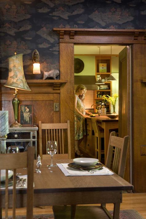 In the dining room, quarter-sawn oak woodwork was never altered; Michelle works at the kitchen’s center island beyond