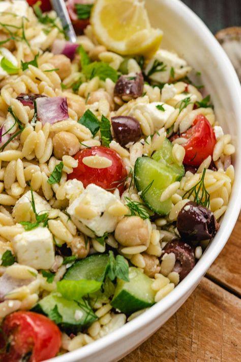 This Lemony Orzo Pasta Salad features fresh and tangy ingredients inspired by Mediterranean flavors. Feta cheese, briny kalamata olives, cucumbers, chickpeas, and more are tossed with a bright lemon vinaigrette that packs in some major deliciousness. Orzo Pasta Salad With Chickpeas, Lemony Orzo Pasta Salad, Meditrainian Orzo Salad, Orzo Salad With Zucchini And Feta, Lemon Orzo Pasta Salad With Feta, Lemony Orzo, Orzo Pasta Salad Recipe, Cookout Dishes, Mediterranean Flavors