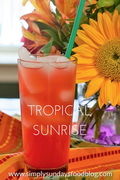 A tall glass of fruity juices on ice with a straw sitting on a colorful cloth with fresh flowers in the background Sunrise Drink, Savory Brunch Recipes, Easter Sunrise, Virgin Cocktails, Refreshing Beverages, Alcholic Drinks, Potluck Party, Drink Inspiration, Fruity Drinks