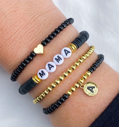 Mama Bracelet 🖤🖤 Simple, chic Mama bracelet, looks cute with any attire!  Made with black clay beads beads, 18k gold accents and gold circle letters that read "Mama" Gold bracelet and accents on bracelets are 18k gold filled  If you would like another word or color, please put in Personalization Section* and we will contact you if we have questions.  CARING TIPS FOR YOUR JEWELRY ⭐️Treat and store with care. ⭐️ For longevity, avoid exposing your jewelry to water. ⭐️ Avoid having direct contact Beaded Bracelets Simple, Diy Charm Bracelet Ideas, Black And White Bracelets, Circle Letters, Black Bead Bracelet, Clay Bracelets, Heishi Bracelet, Mama Bracelet, Homemade Bracelets