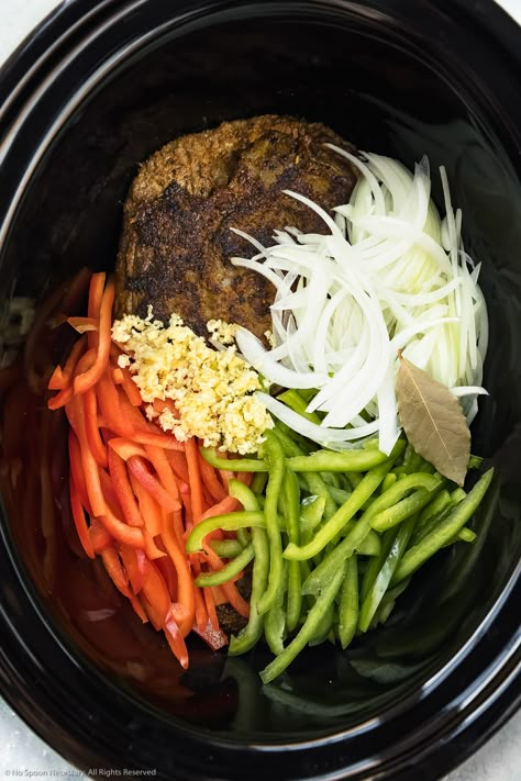 Overhead photo of a black slow cooker bowl filled with browned flank steak, sliced onions, sliced bell peppers, minced garlic and a bay leaf - photo of the first part of step 3 of the Slow Cooker Ropa Vieja recipe. Cuban Ropa Vieja Recipe, Ropa Vieja Slow Cooker, Slow Cooker Flank Steak, Cuban Burger, Cuban Ropa Vieja, Cuban Beef, Ropa Vieja Recipe, Leaf Photo, Bowl Party Food