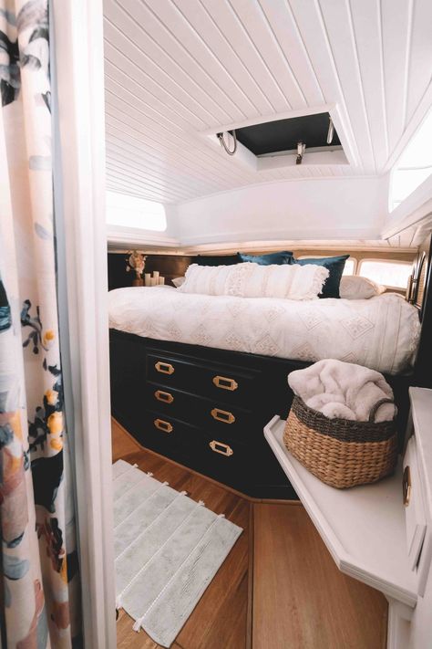 Boat bed with boho white cover and black cabinets with brass hardware Trawler Boat Renovation, Yacht Remodel Boat Interior, Trawler Yacht Interiors, Catamaran Decorating Ideas, Catamaran Interior Design, Liveaboard Boats Interiors, Boho Boat Interior, Modern Sailboat Interior, Silverton Boat Interiors