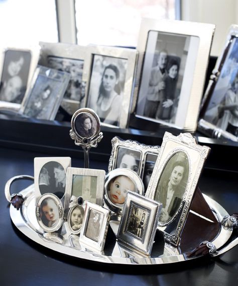 Old and new portraits, in frames of varying heights, develop into a thoughtful vignette when placed on a platter.   - CountryLiving.com Display Collections, Photowall Ideas, Photo Arrangement, Collection Displays, Photograph Display, Display Family Photos, Table Scapes, Collage Ideas, Silver Picture Frames