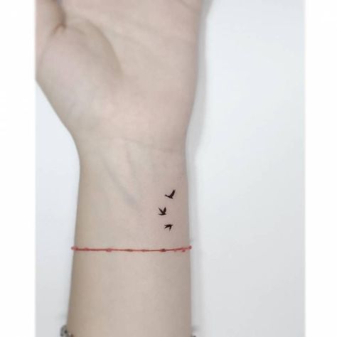 Minimalistic style flying birds tattooed on the wrist. Let It Be Tattoo With Birds, Minimalist Tattoo Freedom, Three Small Birds Tattoo Simple, Small Bird Wrist Tattoos For Women, Three Flying Birds Tattoo, Bird Friendship Tattoos, 3 Birds Tattoo Wrist, Birds Flying Tattoo Arm, Birds On Wrist Tattoo