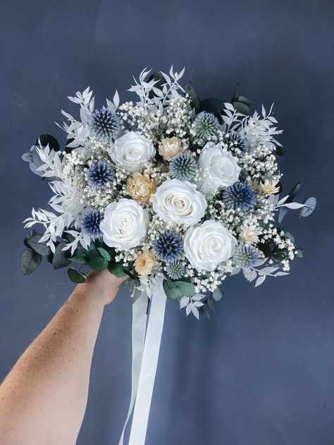 A stunning dried wedding bouquet with white, cream, green and blue tones. This stunning preserved bridal bouquet features 5 long lasting preserved roses for a real wow factor. A beautiful dried wedding bouquet you can treasure Navy Dried Flower Arrangements, Dried Blue Flowers, Blue And White Dried Flower Arrangements, Colourful Dried Flower Bouquet, Dried Flower Bridal Bouquet Blue, Dried Flower Bouquet Wedding, Bridal Bouquet Blue, Preserved Roses, Fresh Cut Flowers