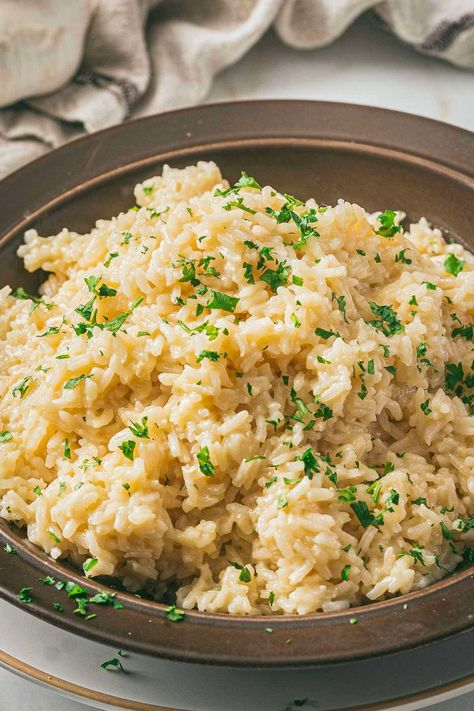 Make this delicious garlic butter rice with parmesan cheese, milk, and chicken broth. It's a flavorful rice side dish that's easy to make and will elevate your dinner! This creamy rice recipe is going to be your new favorite rice side dish recipe. Spinach Parmesan Rice, Parmesan Rice Creamy, Rice Thanksgiving Dishes, Rice For Fish Side Dishes, Garlic Butter Rice Recipes, Cheese Rice Recipe, Rice Dishes Side, Good Rice Recipes, Rice Dishes Recipes Simple