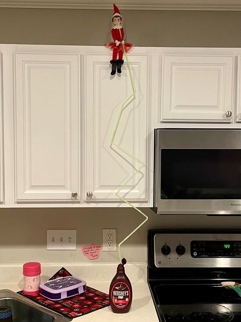 Attached several straws together and our elf is sneaking drinking chocolate syrup from the top of the kitchen cabinets! Elf On The Shelf Straw Ideas, Elf Drinking Syrup, Elf On The Shelf Ideas Kitchen Cabinets, Wlf On The Shelf, Drinking Chocolate, Awesome Elf On The Shelf Ideas, Elf Activities, Xmas Elf, Elf Ideas