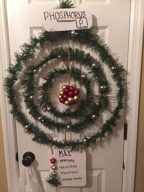 Atom Model Christmas wreath Chemistry Christmas Door Decorations, Chemistry Christmas Tree, Chemistry Ornaments Diy, Laboratory Christmas Decorations, Chemistry Christmas Decorations, Science Christmas Door Decorations, Atom Project Ideas, Lab Christmas Decorations, Science Christmas Decorations