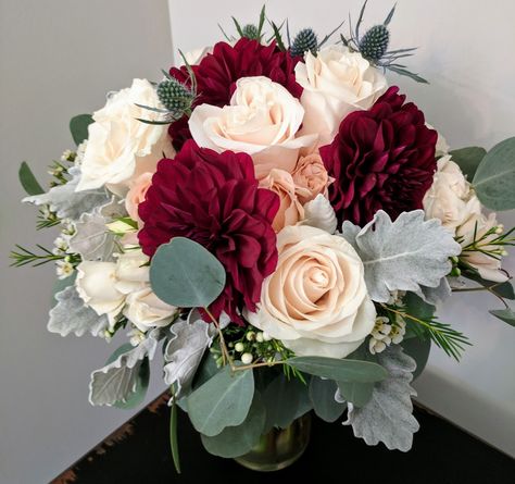 Burgundy dahlia, blue eryngium, ivory Vendela roses, gray dusty miller and white waxflower in a bridesmaid bouquet Burgundy Dahlia Centerpiece, Wedding Bouquets Burgundy, Burgundy Centerpieces, White Waxflower, Blue Eryngium, Bridemaid Bouquet, Vendela Roses, Floral Aesthetics, Winter Bridal Bouquets