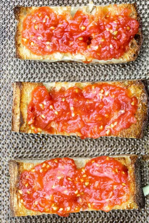 A perfect use of ripe summer tomatoes and day-old bread, Pan con Tomate (Spanish Tomato Bread) is an easy Catalan tapa, made with just 5 ingredients. With a little garlic and tomato, artisan bread is elevated to a whole new level in this recipe. Tomato Bread Recipe, Spanish Tomato Bread, Tomato Dishes, Tomato Bread, Fresh Tomato Recipes, The Mediterranean Dish, Hot Bread, Tapas Dishes, Tapas Recipes