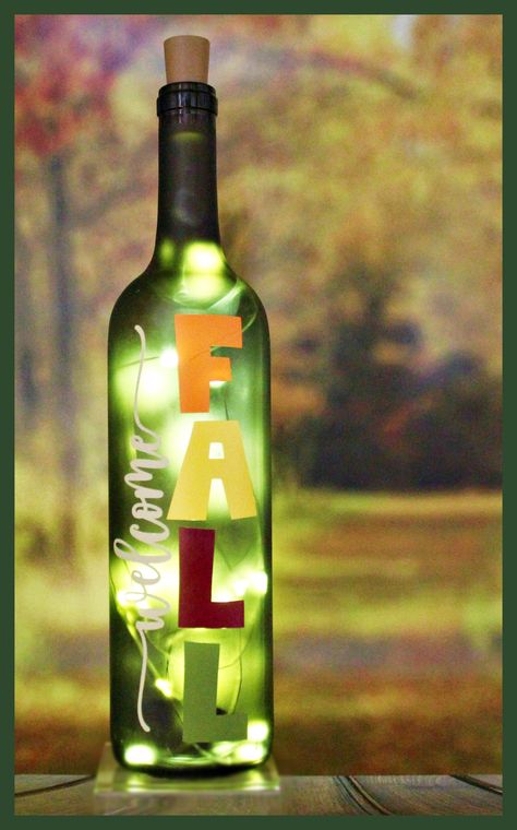 "Welcome Fall-Autumn-Fall-Lighted Wine Bottle-Gift-Home Décor DÉCOR This bottle is a perfect addition for your Autumn décor!  It would also make a great gift for family or friends! It is an 4mber-color, glass wine bottle, painted a light frost with various fall color vinyl, cool white or soft white lights, and a yellow sunflower topper.  Please message me if you are interested in different vinyl colors or a different topper. Additional Autumn bottle toppers can be found here, https://www.etsy.co Fall Crafts With Wine Bottles, Spring Wine Bottle Crafts, Thanksgiving Wine Bottle Decorations, Fall Decor Wine Bottles, Fall Wine Bottles With Flowers, Fall Decorated Wine Bottles, Wine Bottle Fall Decor Diy Projects, Fall Wine Bottles, Glass Bottle Diy