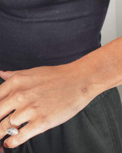 Tiny letter "D" tattoo located on the wrist. Tattoos Letters Styles, Mini Initial Tattoo On Finger, Tiny Letter Tattoo Wrist, D Tattoos Letter, Lowercase D Tattoo, Initials Finger Tattoo, Wrist Tiny Tattoo, Minimal Tattoo Initials, The Letter D Tattoo