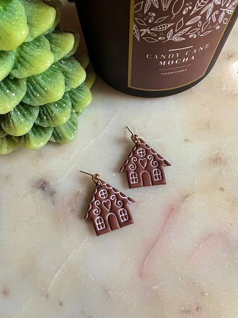 A pair of gingerbread house earrings made from polymer clay. Xmas Polymer Clay, Gingerbread Clay Earrings, Gingerbread House Earrings, Polymer Clay Holiday Earrings, Holiday Polymer Clay Earrings, Polymer Clay Fall Earrings, Winter Polymer Clay Earrings, Christmas Clay Crafts, Christmas Earrings Polymer Clay