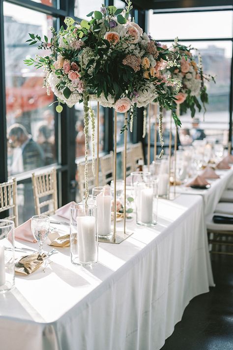 Wedding Reception Head Table with White Linens and Tall Centerpieces of Hydrangeas and Peach Roses with White Pillar Candles and Pink Silk Napkins Minimal Wedding Table Decor, Silk Napkins, Minimal Wedding Table, Reception Designs, Spring Wedding Ceremony, Spring Wedding Reception, Wedding Reception Head Table, Reception Head Table, Wisteria Wedding