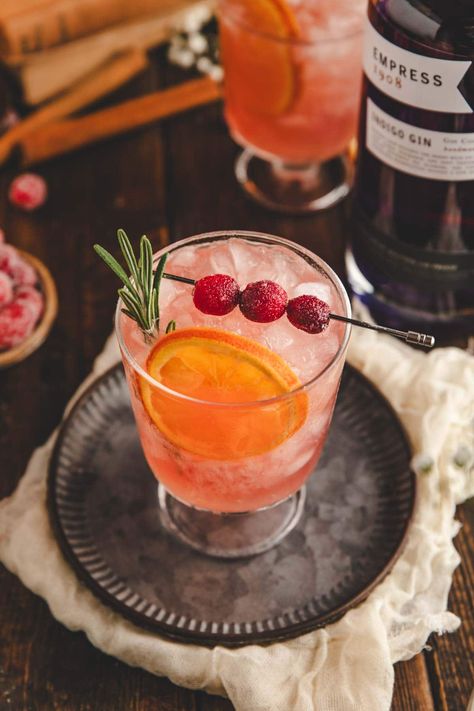 A 5-minute cranberry gin cocktail perfect for the holidays. A combination of gin, citrus juices, cranberry juice, bitters, and ginger beer. Garnished with dried orange, sugared cranberries, and a sprig of rosemary. The best!  Pitcher instructions included. Cocktails With Cranberry Juice, Cranberry Gin Fizz, Bread Christmas Tree, Vintage Nye, Arbonne 30 Day Challenge, Xmas Cocktails, Ginger Beer Cocktail, Caramel Apple Cider, Gin Fizz Cocktail