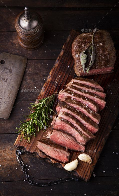 Sliced medium rare grilled beef steak with salt, rosemary and garlic by DmitriBelokoni. Sliced medium rare grilled beef steak with salt, rosemary and garlic on dark background #Sponsored #grilled, #beef, #steak, #Sliced Sommer Mad, Beef Tenderloin Roast, Rare Steak, Tenderloin Roast, Spice Bottles, Grilled Beef, Beef Tenderloin, Beef Cuts, Steak Dinner